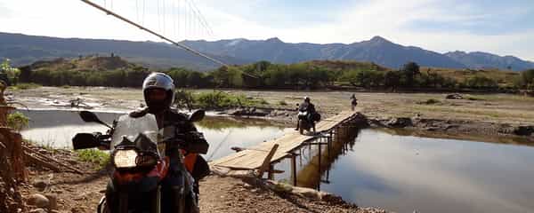 Motorcycle riders crossing a bridge in Colombia.