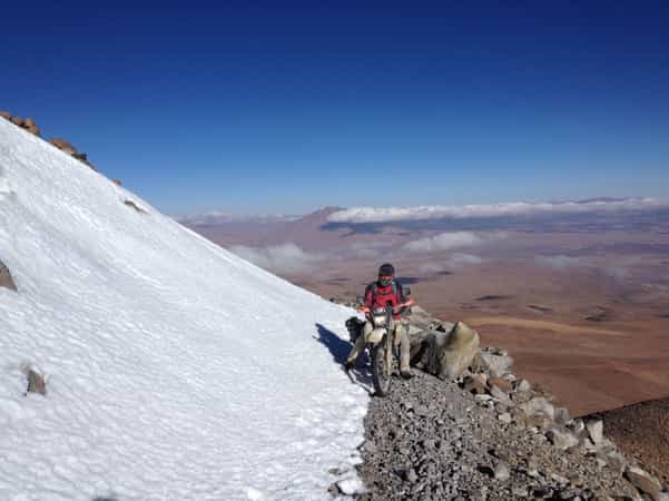 Customer on top of a mountain in Bolivia riding a small single track trail.