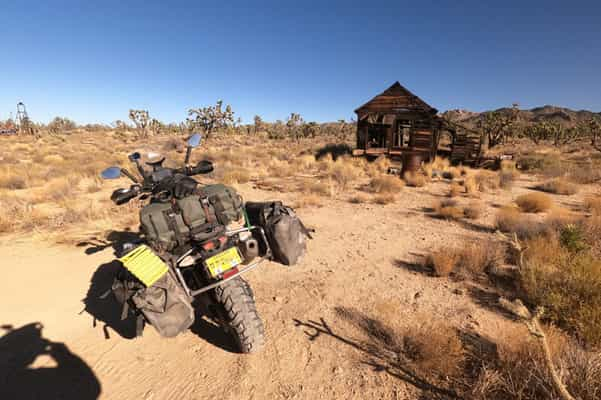 Garrett's riding the KTM 790 Adventure motorcycle with racked soft luggage attached.