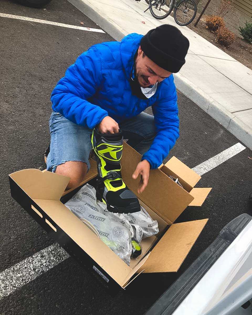 Garrett opening a box containing his brand new pair of Klim Adventure GTX boots.