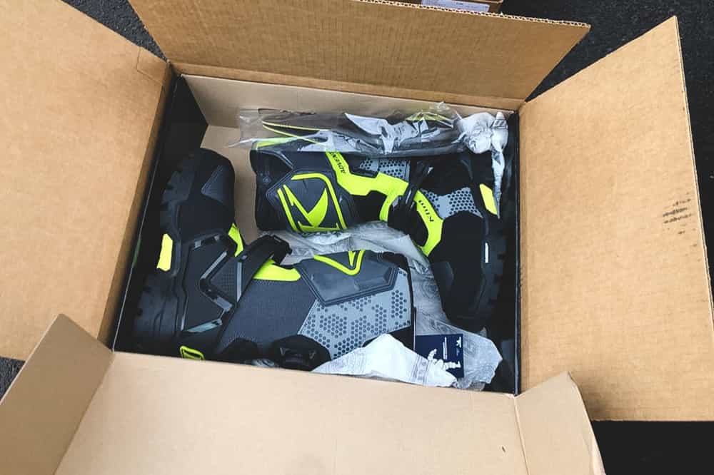 Close up shot of the Klim Adventure GTX boots inside the box with all the accesories that come with it like the gel insert soles.