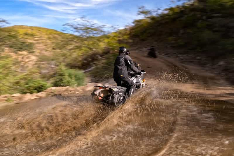 Tyler railing a water crossing while wearing the Badlands Pro jacket by Klim. 